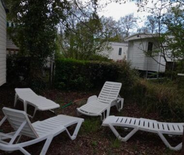 Espace détente avec transats sous les arbres au KERLANN****MOBIL-HOME 4 CH TOUT CONFORT