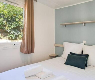 Chambre avec lit et fenêtre sur verdure du Kabana La palmeraie