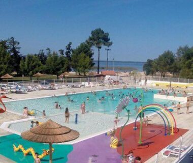 Piscine extérieure avec toboggans et jeux aquatiques au Kélya Lodge