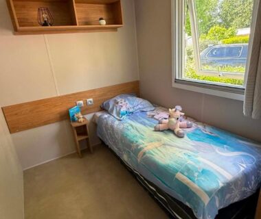 Chambre avec lit simple et peluche au Kélya Lodge
