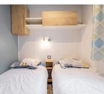 Chambre avec deux lits simples et table de chevet dans le camping Kerlann
