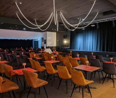 Salle de spectacle intérieure avec scène et tables au camping L EVASION