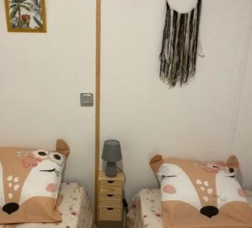 Chambre avec deux lits simples et attrape-rêves du camping L éden