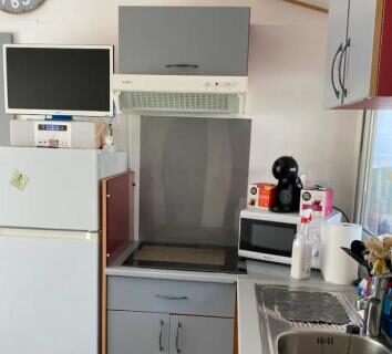 Cuisine équipée avec réfrigérateur plaque évier et machine à café dans le mobil-home L éden