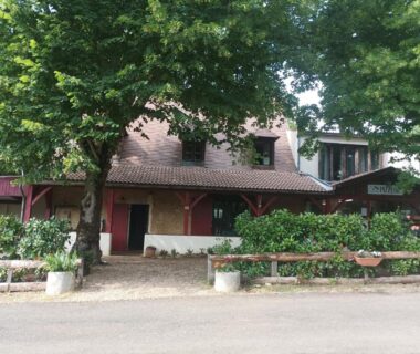 Façade ombragée avec terrasses et arbres devant L escale de larcher