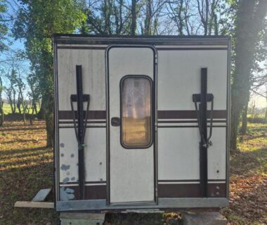 Sous-bois avec caravane arrière et porte au camping L insolite
