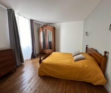 Chambre double avec lit moutarde et armoire en bois à la Vieille Auberge
