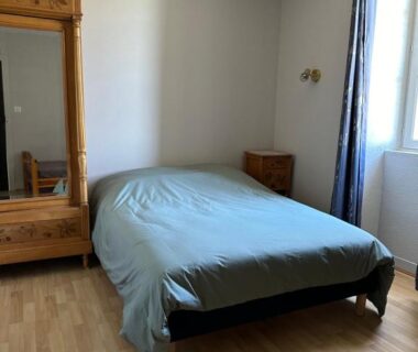 Chambre avec lit double et armoire dans le camping LA VIEILLE AUBERGE