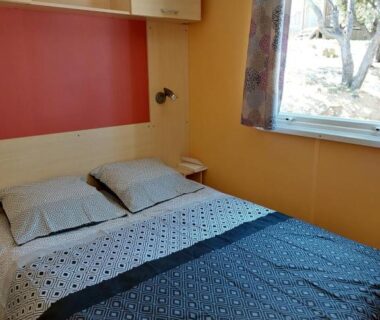 Chambre double avec lit et fenêtre au camping LAVATOGGIO