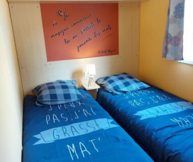 Chambre avec deux lits simples et lampe dans le camping LAVATOGGIO