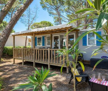Terrasse ombragée avec salon extérieur sous pins du L'Alizé Mobil Home 6 personnes