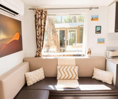 Salon avec banquette et fenêtre donnant sur terrasse du L'Alizé Mobil Home 6 personnes