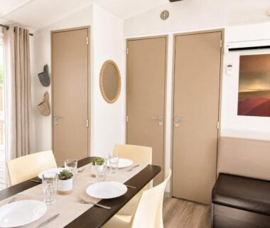 Intérieur coin repas avec table dressée dans L'Alizé Mobil Home 6 personnes