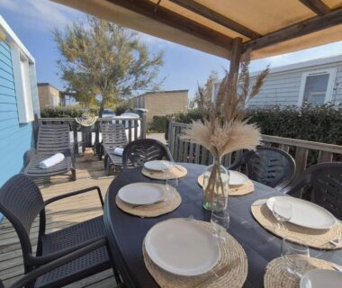 Terrasse aménagée avec table et vaisselle du L'Azura Mobil Home 6 personnes Piscines & Plage Camping Les Dunes