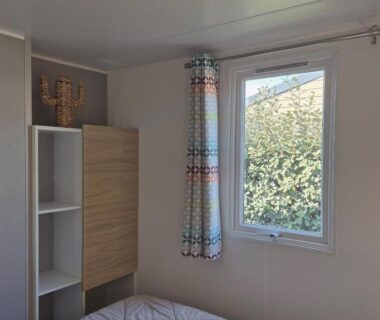 Intérieur chambre avec lit, fenêtre et rangement dans le mobil home L'Azura Mobil Home 6 personnes