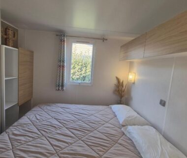 Chambre avec grand lit et fenêtre dans le mobil home L'Azura 6 personnes