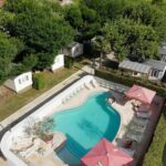 Piscine extérieure avec parasols et transats au camping LE CASQUE ROI