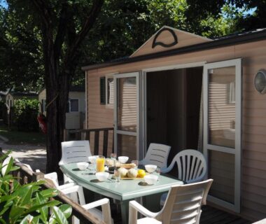 Terrasse de mobil-home avec table et petit déjeuner du camping LE CASQUE ROI