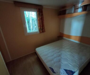 Chambre avec matelas et fenêtre dans le mobil home LE CORNOUILLER
