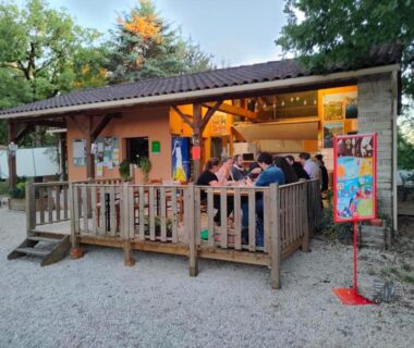 Terrasse en bois avec convives et guirlandes au mobil home LE CORNOUILLER du Camping Le Bel Air