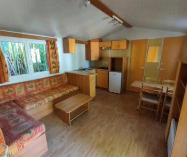 Séjour avec kitchenette et canapé dans le mobil home LE CORNOUILLER