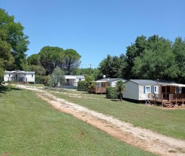 Allée herbeuse et mobil-homes au camping Le Bel Air mobil home Le Cornouiller