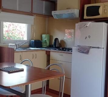 Coin cuisine et espace repas dans le mobil home LE FIGUIER