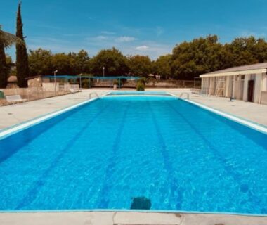Piscine extérieure bordée de solarium au camping Le Bel Air Le Fresne cabane insolite