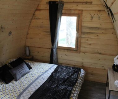 Intérieur en bois avec lit double dans la cabane LE FRESNE du CAMPING LE BEL AIR Limogne en Quercy