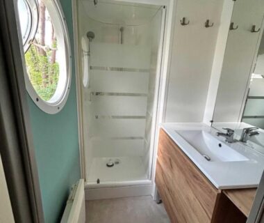 Salle de bain avec douche et vasque dans l'hébergement LE ILÔ camping la dune blanche
