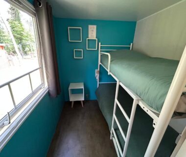 Cabine avec lits superposés et fenêtre dans LE ILÔ camping la dune blanche