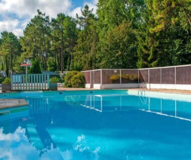 Piscine extérieure entourée de pins au camping LE ILÔ la dune blanche