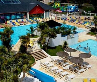 Piscine extérieure avec transats et parasols au camping LE PETIT BONHEUR