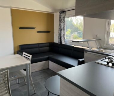 Séjour avec canapé d'angle et kitchenette dans le mobilhome LE PIPA