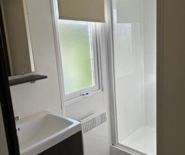 Salle de bain avec douche et lavabo dans le camping LES PIERRES CHAUDES
