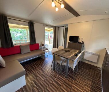 Séjour avec canapé table et kitchenette dans le mobil-home LES PIERRES CHAUDES