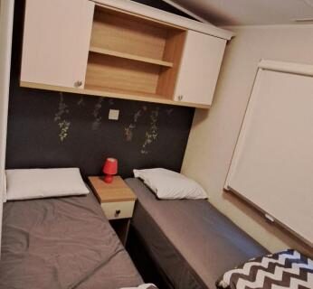 Intérieur de mobil-home avec deux lits simples au camping L'Exellence