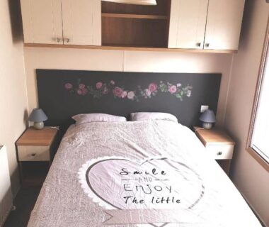 Chambre avec lit double et rangements muraux dans le camping L’Exellence