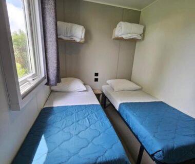 Chambre avec deux lits simples et fenêtre dans l'hébergement L’Instant Yole