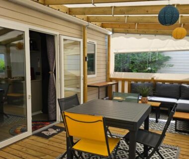 Terrasse couverte avec table chaises et lanternes au mobil-home L'Instant Yole