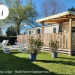 Terrasse en bois avec chaises longues sur pelouse du LJ Cosy Lodge Mobilhome