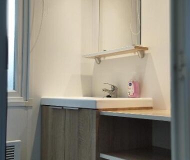 Salle de bain avec lavabo et miroir dans le mobilhome LJ Cosy Lodge