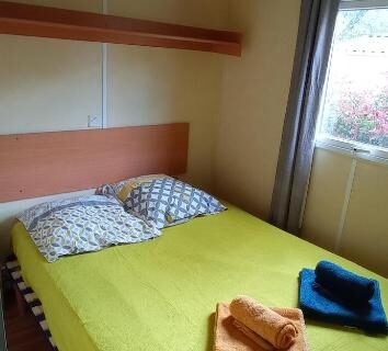 Chambre avec lit double et serviettes dans le mobil home L'OLIVIER