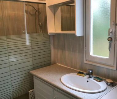 Salle de bain avec lavabo et douche dans le chalet LOUE JOLI CHALET EN BOIS