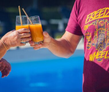 Bord de piscine avec deux verres d'apéritif au camping L'Oasis des Dombes