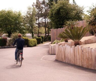 Allée du camping avec un cycliste et plantations dans L'Orée de l'Océan