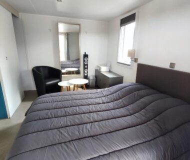Chambre intérieure avec lit double et fauteuils dans le LUXUEUX MOBIL-HOME