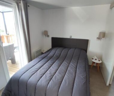 Chambre avec lit double et baie vitrée du LUXUEUX MOBIL-HOME