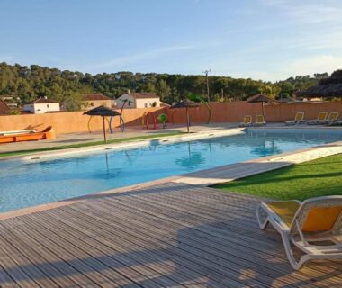 Terrasse au bord de la piscine avec transats du LUXUEUX MOBIL-HOME