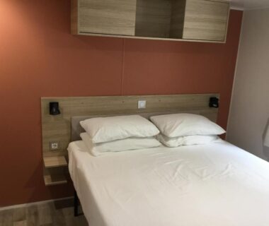 Chambre avec lit double et rangements dans le camping La Baume 515